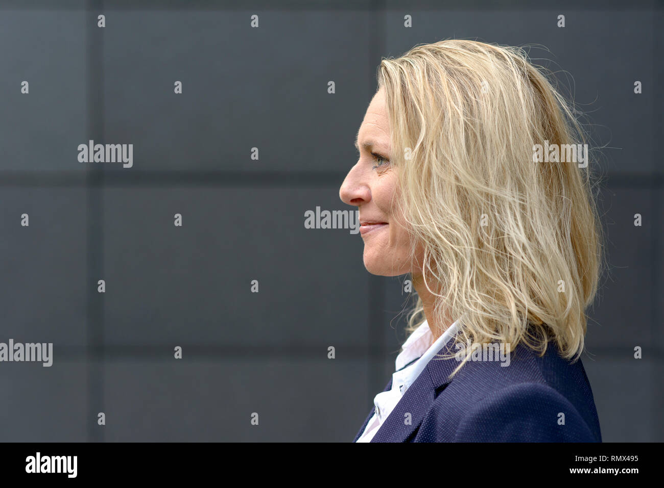 Profile head shot of a happy blonde femme avec les cheveux ébouriffés smiling with copy space Banque D'Images