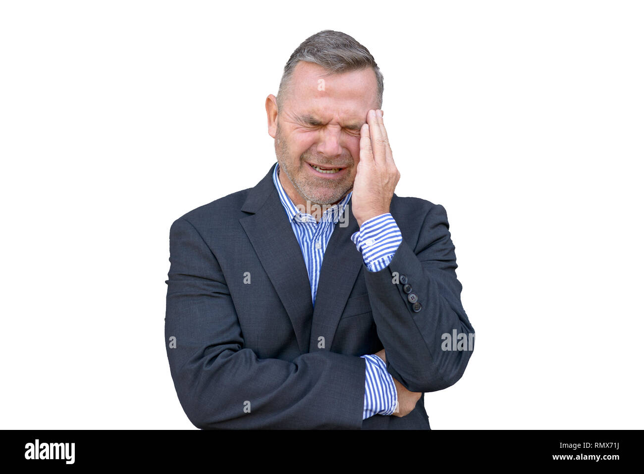 Stressed businessman, ou souffrant d'un mal de tête, debout avec sa main à son temple grimaçant contre fond blanc Banque D'Images