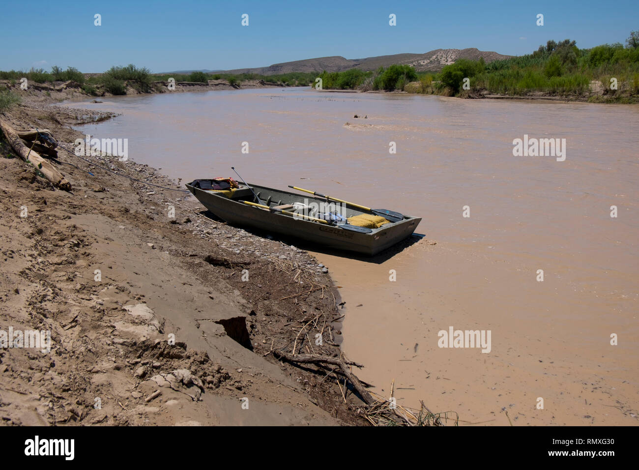 Un petit bateau, yole, attend sur le côté américain de la Rio Grande en face de Boquillas del Carmen, au Mexique. Banque D'Images