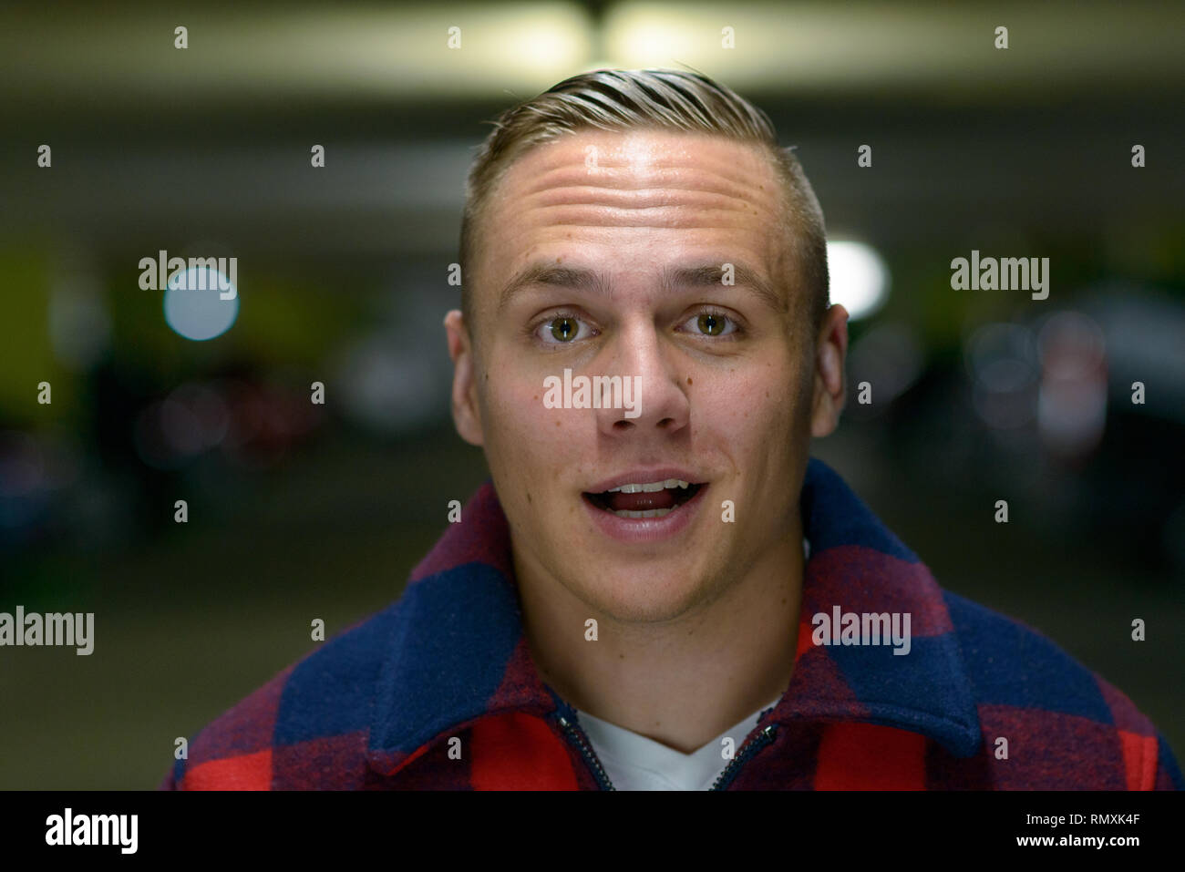 Un jeune homme élégant, métro, au milieu de conversation regardant la caméra dans une localisation urbaine. Banque D'Images