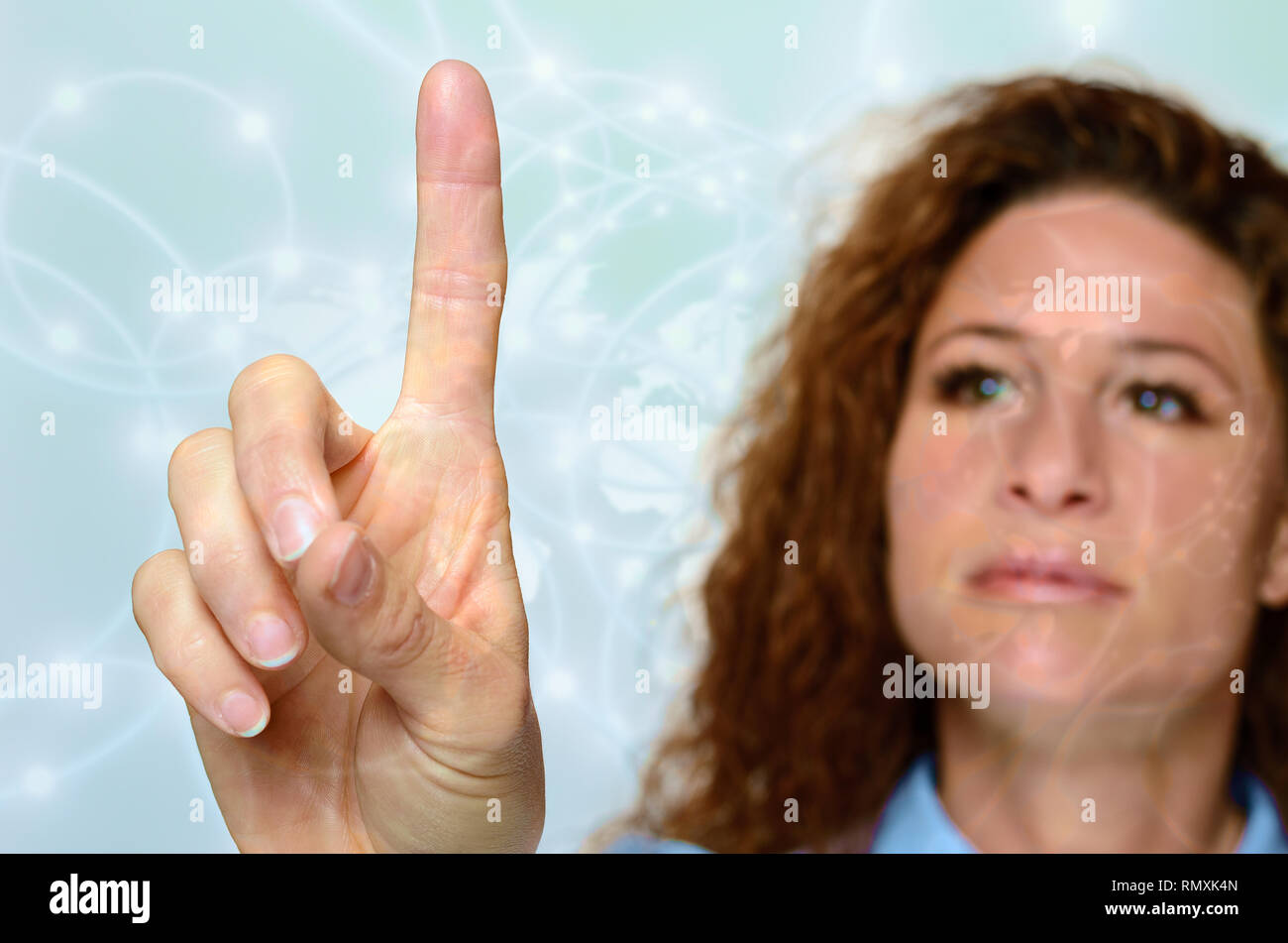 Une femme ayant atteint avec un doigt pour toucher un écran ou une interface virtuelle, Close up de sa main avec son visage alors qu'un flou derrière Banque D'Images