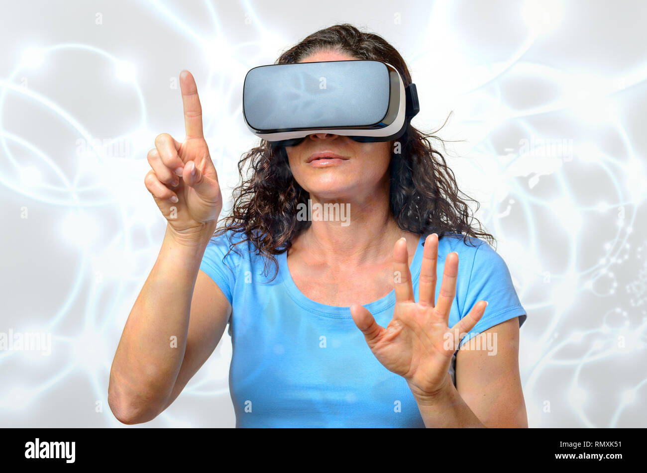 Femme victime d'un environnement virtuel alors qu'elle voit les graphiques simulées sur une paire de lunettes de réalité virtuelle avec une expression grave faisant Banque D'Images