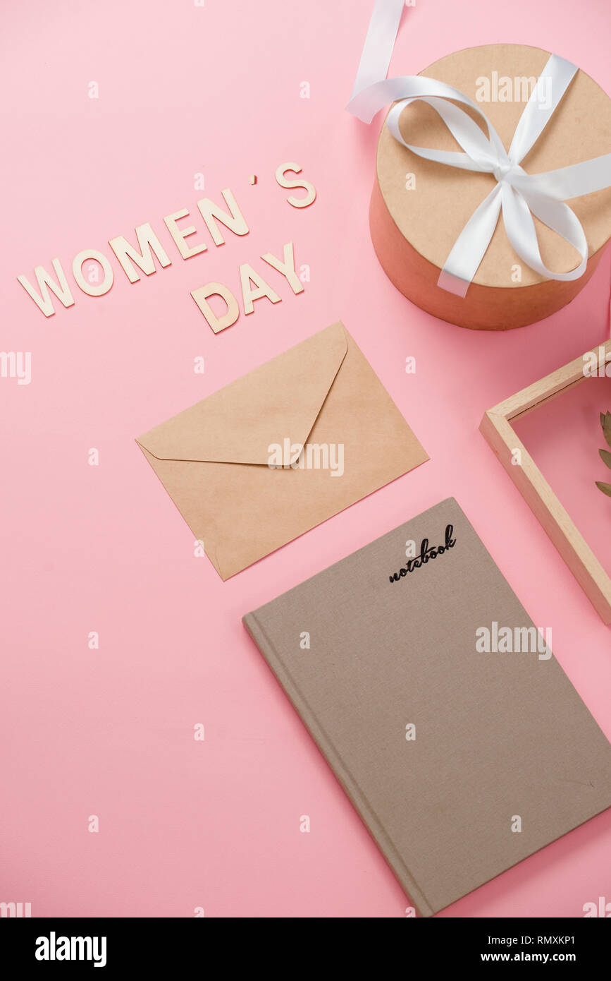 La journée de la femme, concept heureux jour de la femme, Journée internationale de la femme. Texte jour Womans, en bois avec cadre cadeau rose sur fond de corail Banque D'Images