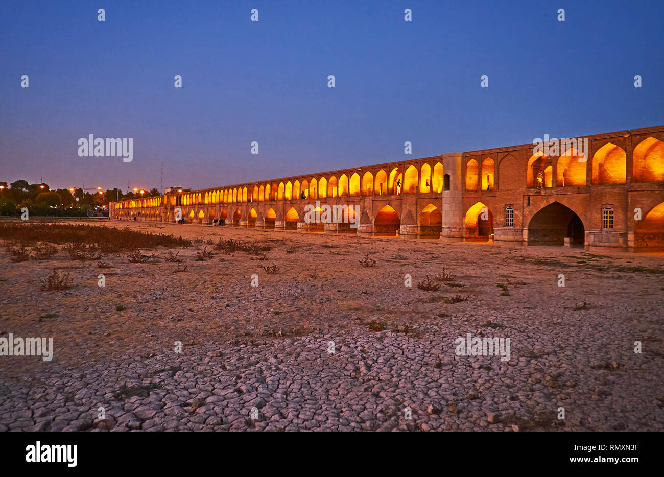 Promenade du soir le long de la banque de taris Zayanderud rivière avec vue sur le pont historique éclairées Siosepol, Isfahan, Iran. Banque D'Images