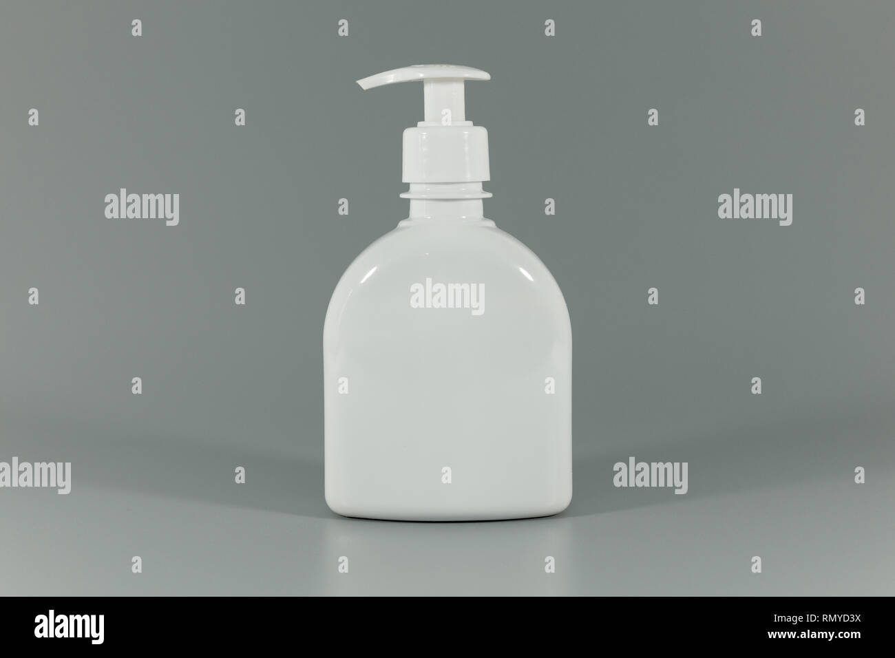 Pompe flacon parfum vide blanc sur fond gris Banque D'Images