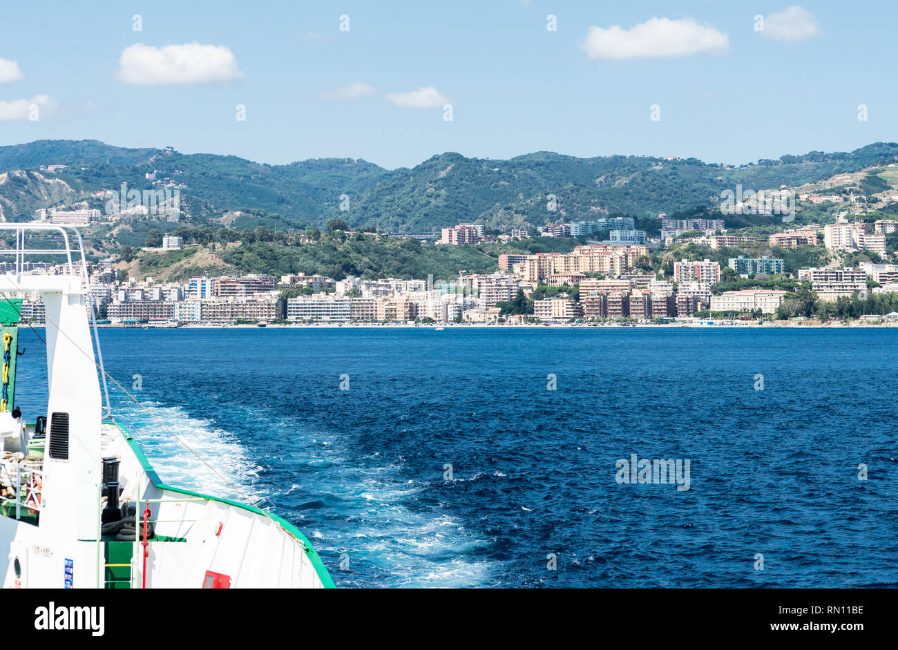 Vue sur la mer de l'arrière d'un car-ferry à travers le détroit de Messine et à l'arrière-plan la ville de Messine. Voir l'Orizontal Banque D'Images