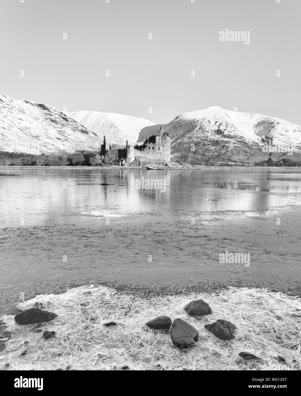 Tôt le matin, au château de Kilchurn et Loch Awe, Argyll and Bute, Ecosse, ROYAUME UNI sur une journée d'hivers froids avec de la neige gelée et le loch - noir & blanc et Banque D'Images