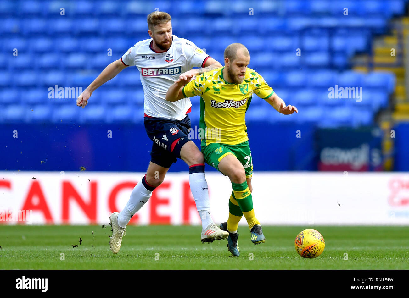 Bolton Wanderers' Mark Beevers (à gauche) et de la ville de Norwich Teemu Pukki bataille pour le ballon pendant le match de championnat Sky Bet à l'Université de Bolton Stadium. Banque D'Images