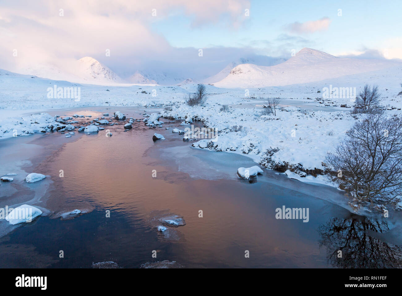 Froid matin d'hiver avec le loch partiellement gelé et le lever du soleil reflétée dans l'eau dans le Loch Rannoch Moor, Ba, l'Argyll and Bute en Janvier Banque D'Images