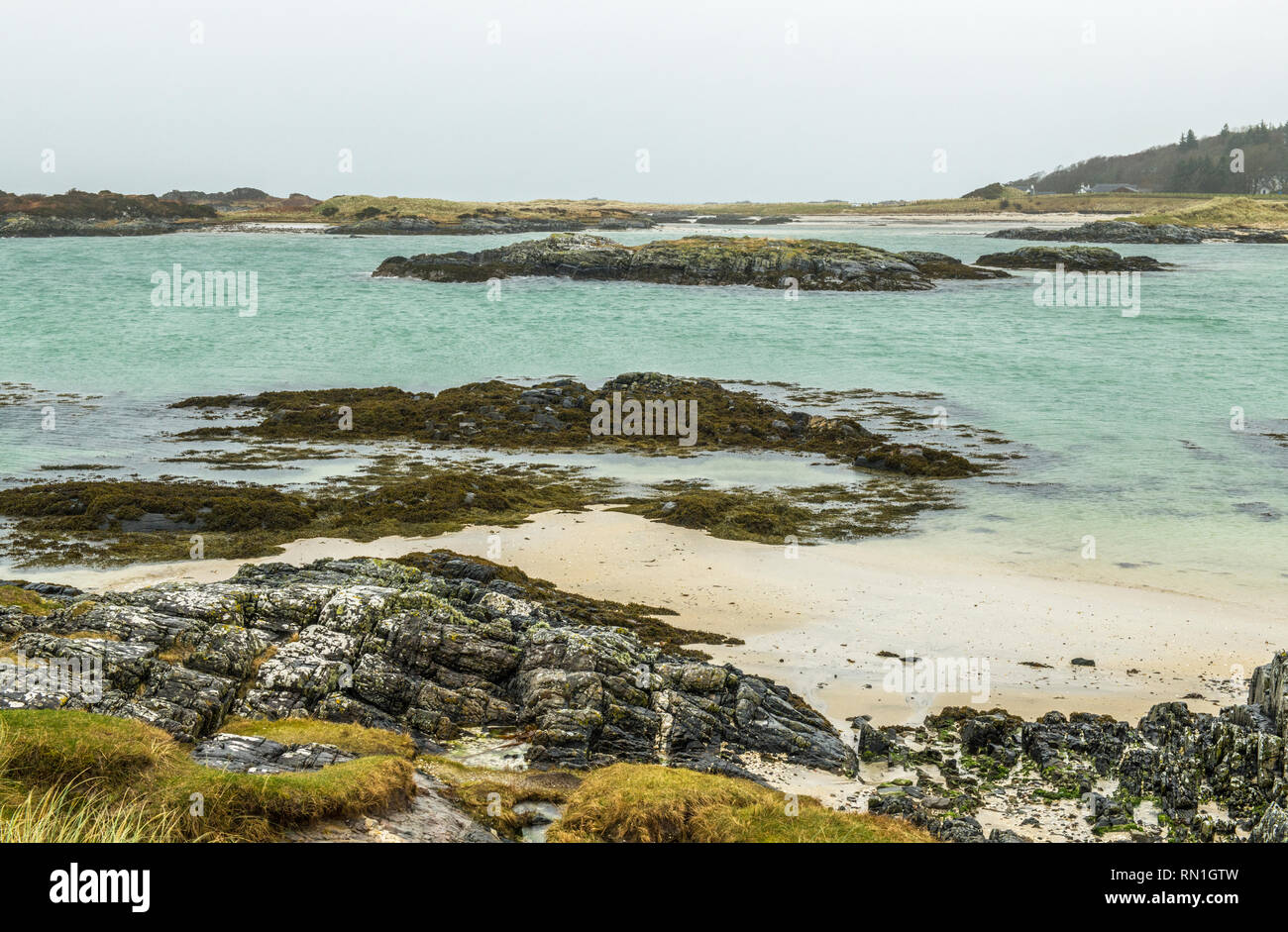 Plage de Traigh à l'ouest de la Côte d'Écosse près de Mallaig, photographié sur un jour de temps gris mais toujours avec beaucoup de détail des roches, du sable et de la mer. Banque D'Images