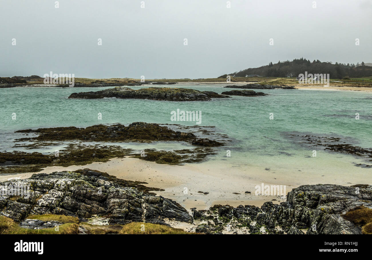 Plage de Traigh à l'ouest de la Côte d'Écosse près de Mallaig, photographié sur un jour de temps gris mais toujours avec beaucoup de détail des roches, du sable et de la mer. Banque D'Images