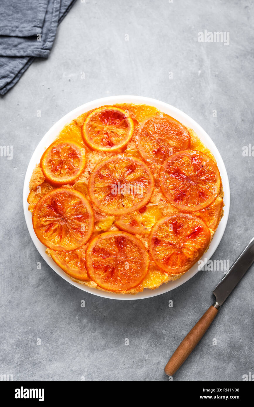 Upside down cake orange sur fond gris, l'espace de copie. Gâteau fait maison avec du sang les oranges, les agrumes. Banque D'Images