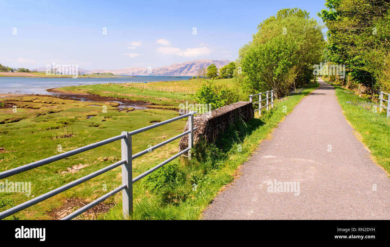 Le soleil brille sur la Nouvelle-calédonie chemin de randonnée et trail, converti à partir d'une voie ferrée désaffectée le long de la côte du Loch Laich et le Loch Linnhe en vertu de la mo Banque D'Images