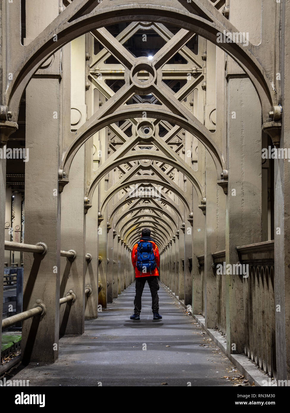 Un homme se tient sur le chemin de fer récurrent qui prend en charge les arches du fleuve Tyne Bridge de haut niveau entre Newcastle et Gateshead. Banque D'Images