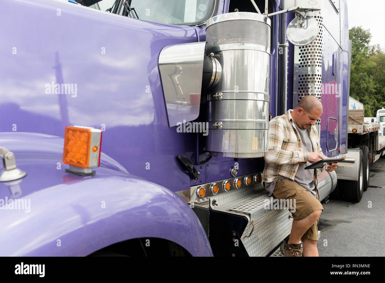 Chauffeur de camion travaillant sur tablette numérique par son semi-truck Banque D'Images