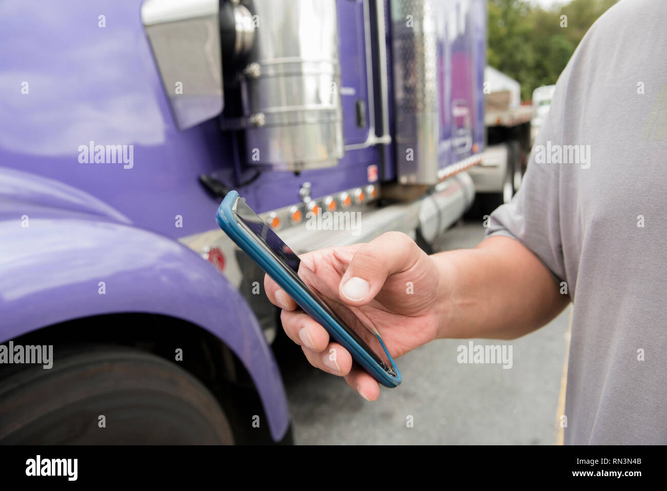 Main de chauffeur de camion à l'aide de smart phone Banque D'Images