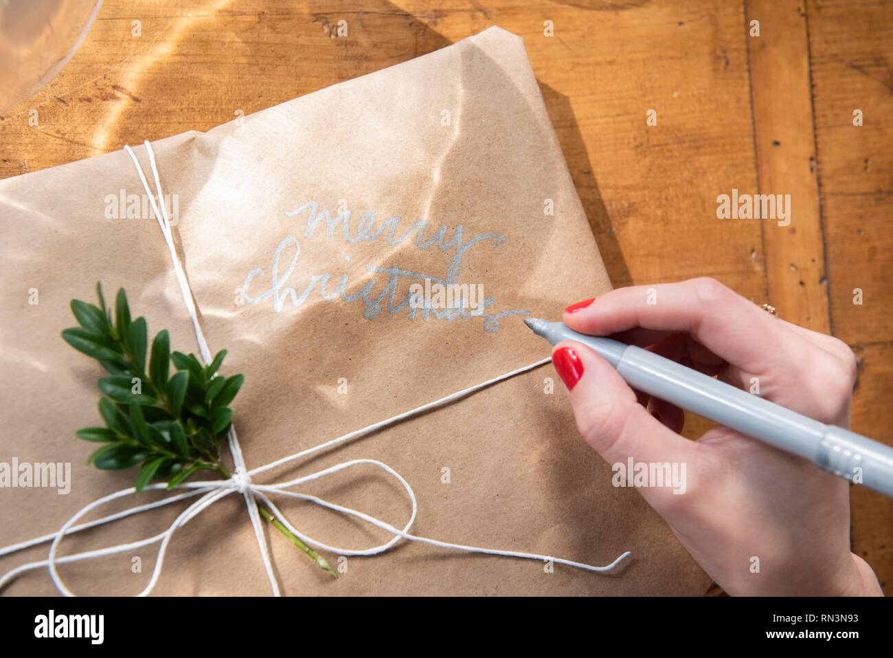 Main de femme écrit sur cadeau de Noël Banque D'Images Main de femme écrit sur cadeau de Noël Banque D'Images