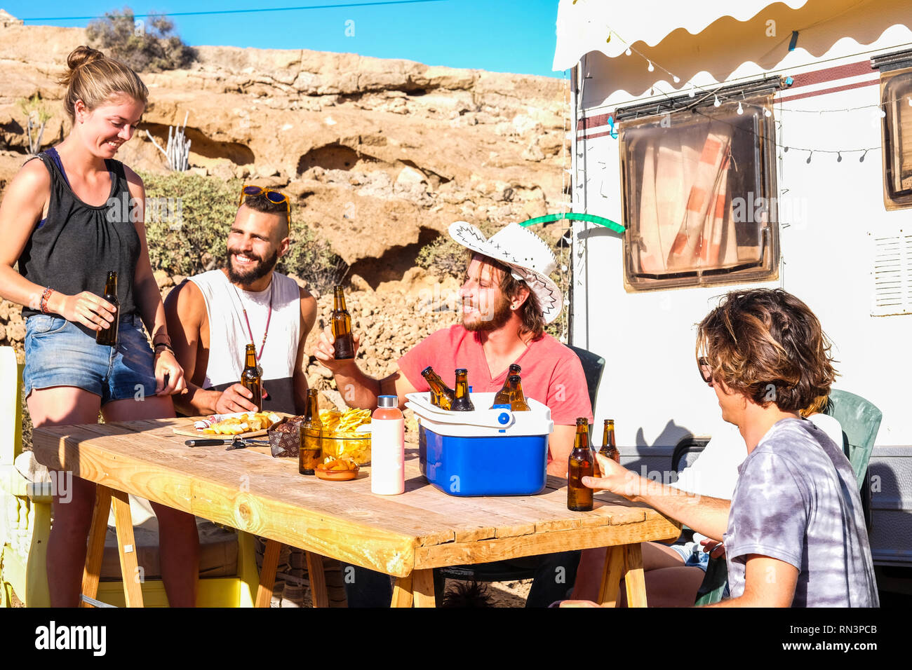 Les amis de s'amuser et de boire une bière froide en caravane emplacement camping hipster traveler - les jeunes de l'amitié fêter tous ensemble Banque D'Images
