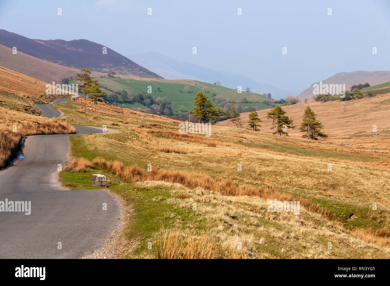 Un étroit chemin de campagne serpente à travers la lande de montagne dans la vallée de Newlands en Angleterre's Lake District National Park. Banque D'Images