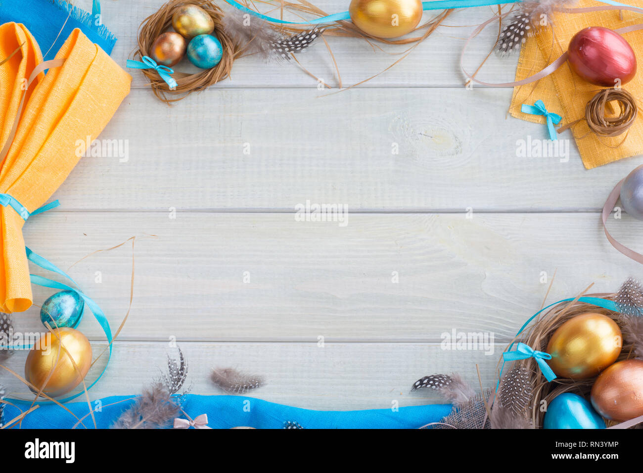 Joyeuses Pâques border frame avec copie espace pour texte haut de la page Avis télévision jeter des oeufs de pâques plumes nid fith rubans arcs et tissu plié à oreilles de lapin Banque D'Images