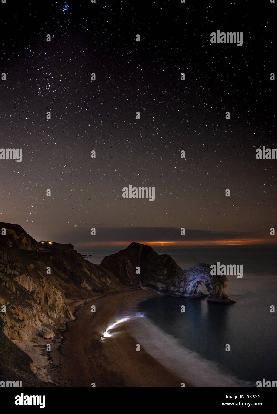 Stars remplir le ciel nocturne au-dessus de Durdle Door sur la côte jurassique du Dorset. Banque D'Images