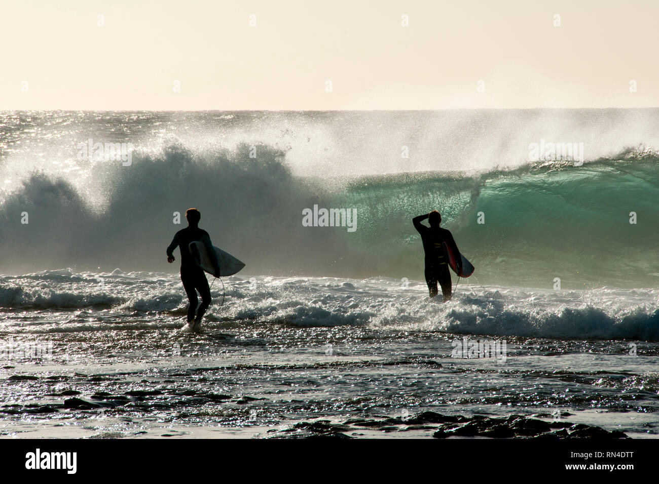 Surfers Silhouette dans Ocean Banque D'Images