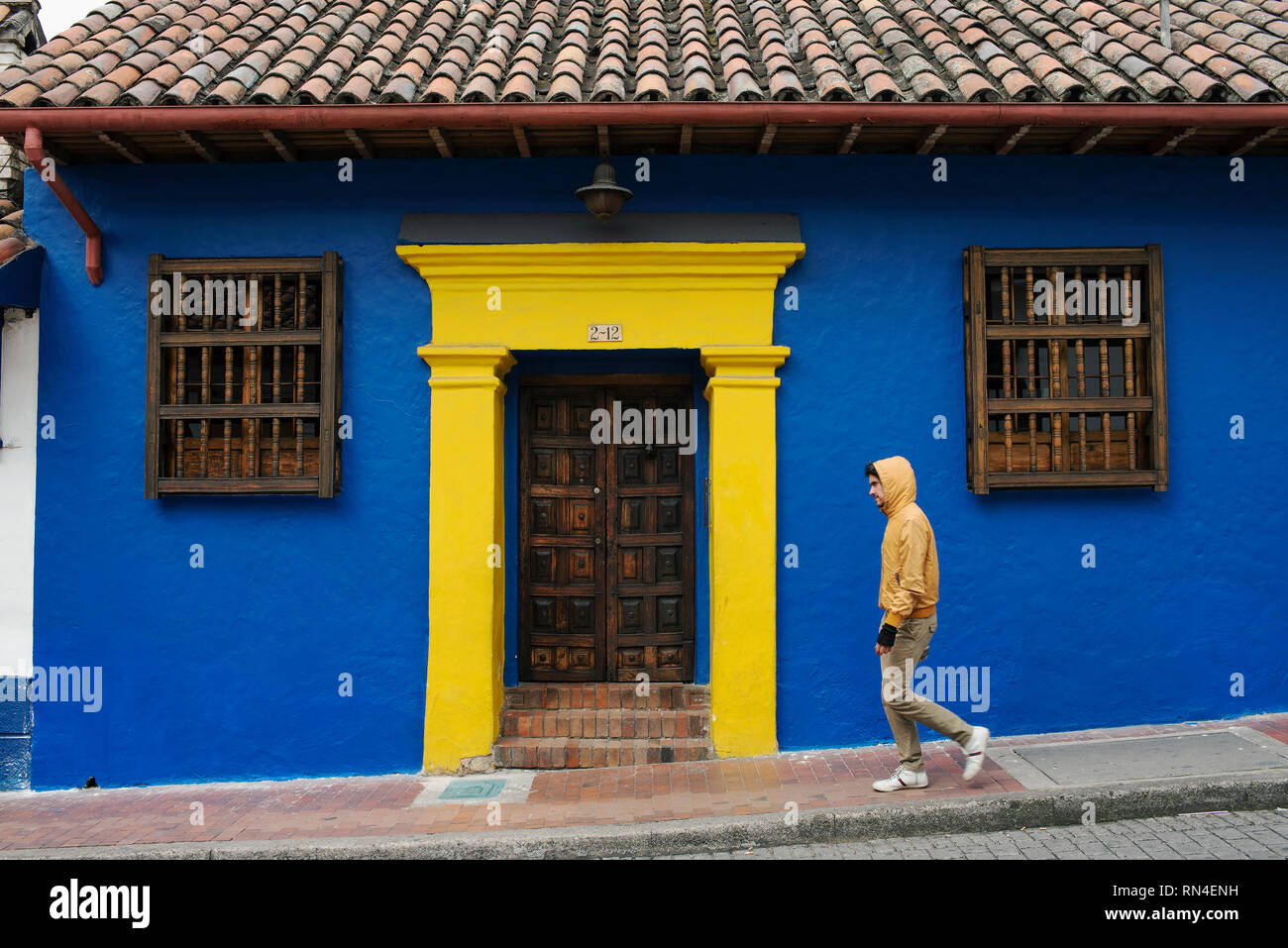 Résident Local marcher passé colonial house portant tenue décontractée avec des couleurs assorties. La Candelaria, le centre historique de la ville de Bogota, Colombie. Sep 2018 Banque D'Images