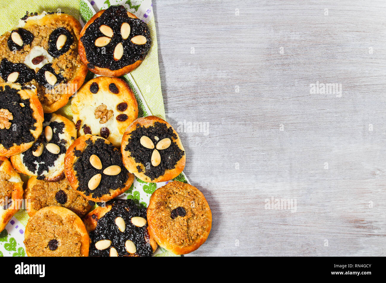 Groupe de gâteau avec de la levure, l'amande pavot, raisins et fromage avec serviette sur bois blanc Banque D'Images