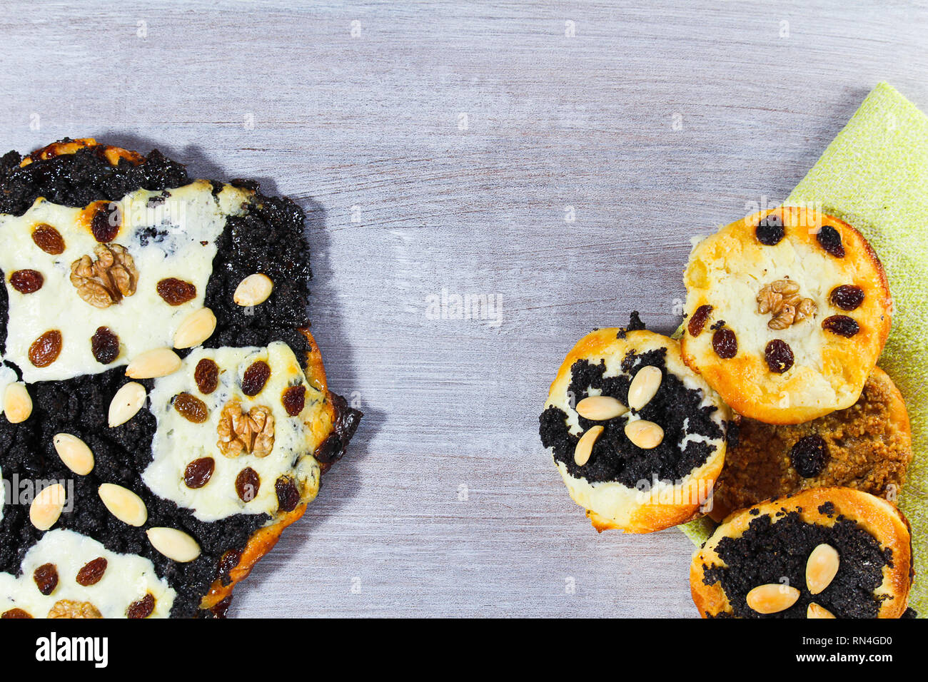 Gâteau de levure avec poppy, amande, raisins et fromage avec serviette sur bois blanc Banque D'Images