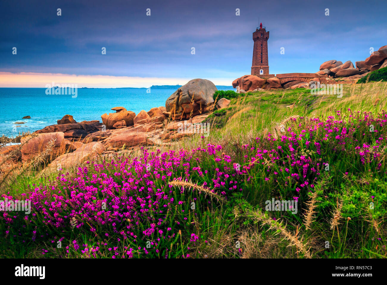 Le phare de belle pierre et coloré des fleurs roses au coucher du soleil, Perros Guirec, Bretagne (Bretagne), France, Europe Banque D'Images
