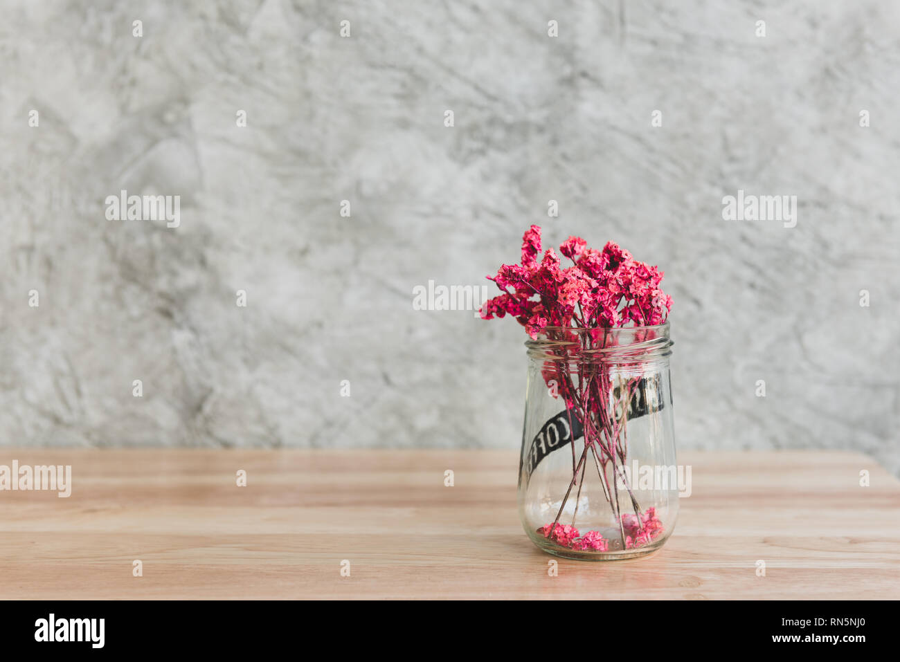 Rose Belle fleurs séchées dans un vase en verre décoré sur bois tableau de café café Banque D'Images