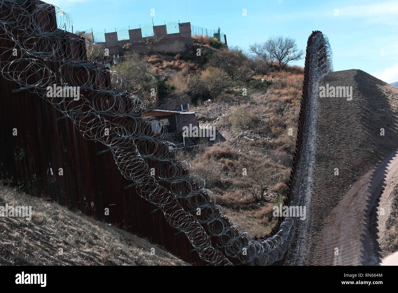 Nogales, Arizona, USA. 16 Février, 2019. Les ingénieurs de l'armée américaine a ajouté plusieurs plusieurs rangées de barbelés à la frontière qui sépare le mur de Nogales, Arizona de Nogales, Sonora au Mexique. Trump président envoyé plusieurs milliers de soldats américains à la frontière qui a ajouté deux rangées de barbelés en haut de la clôture le jour de l'élection. Credit : ZUMA Press, Inc./Alamy Live News Banque D'Images
