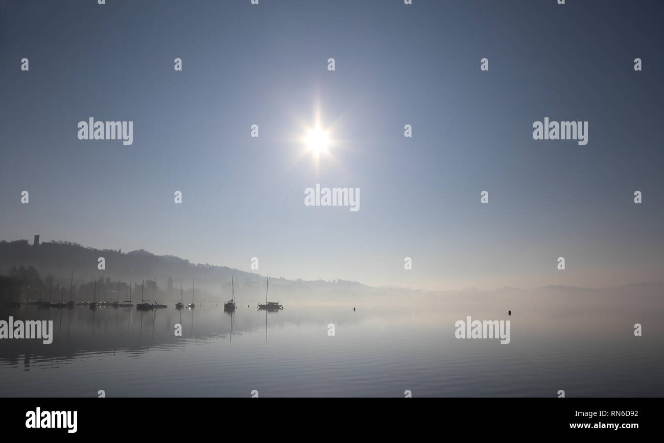 bateaux qui se réfléchit sur l'eau, dans le brouillard et au soleil Banque D'Images