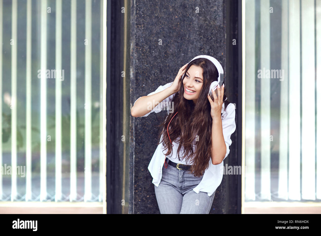 Jeune femme élégante avec un casque sur la rue Banque D'Images