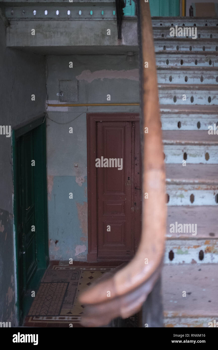 Deux portes dans un immeuble délabré avec un un escalier en bois menant à d'autres étages. Banque D'Images