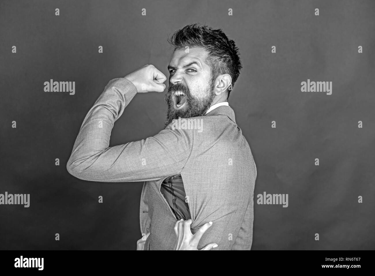 Guy en colère ont acheté ou contrefaçon de marque contrefaits. Veste homme  avec porte la barbe avec le trou de l'arrière-plan sombre. Hipster a choisi  de petite taille, veste déchirée avec couture