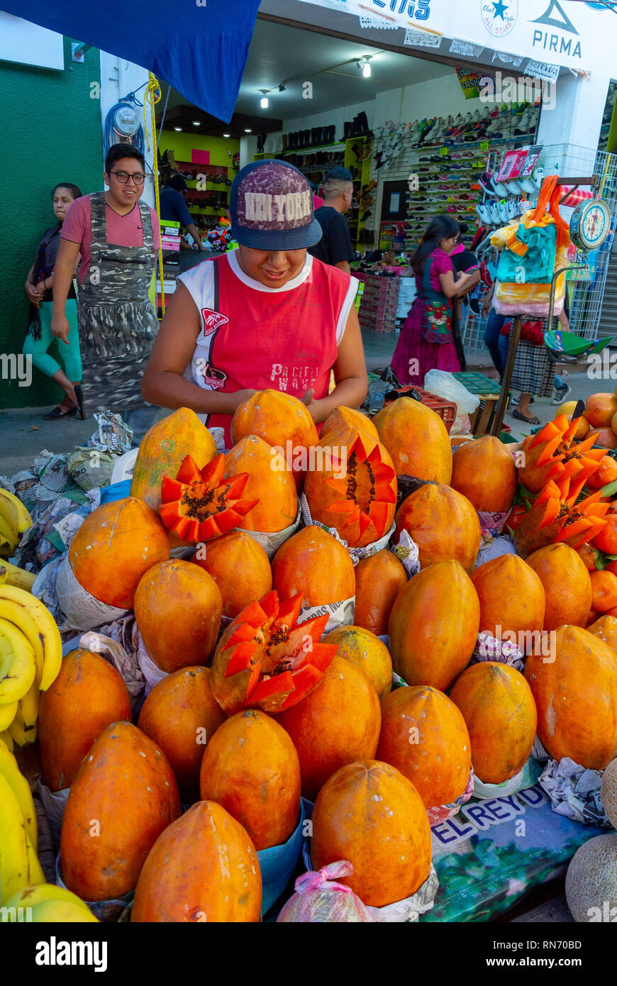 Jeune homme local fruits vente stand à un traditionnel marché de Tlacolula, Oaxaca, Mexique Banque D'Images