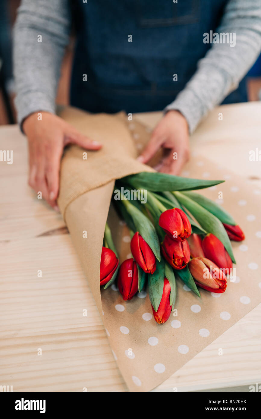 L'homme rend fleuriste bouquet de tulipes rouges et rétractable en pack ...