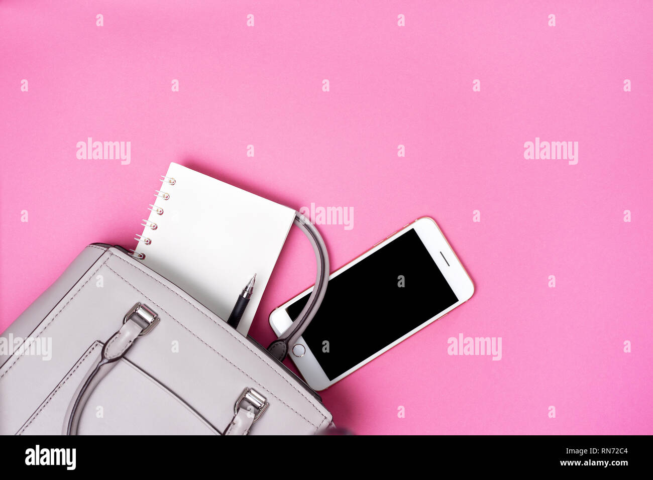 Les femmes gris et sac ordinateur portable, smartphone sur un fond rose. Vue de dessus. copy space Banque D'Images