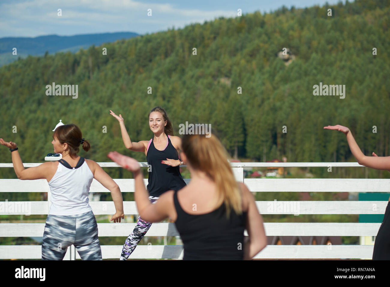 Formation de coach professionnel de forme physique sports, montrant se déplace à des femmes. Répétition du groupe se déplace, faisant des exercices de remise en forme et la pratique de l'air frais. Les femmes portant dans les vêtements de sport. Banque D'Images