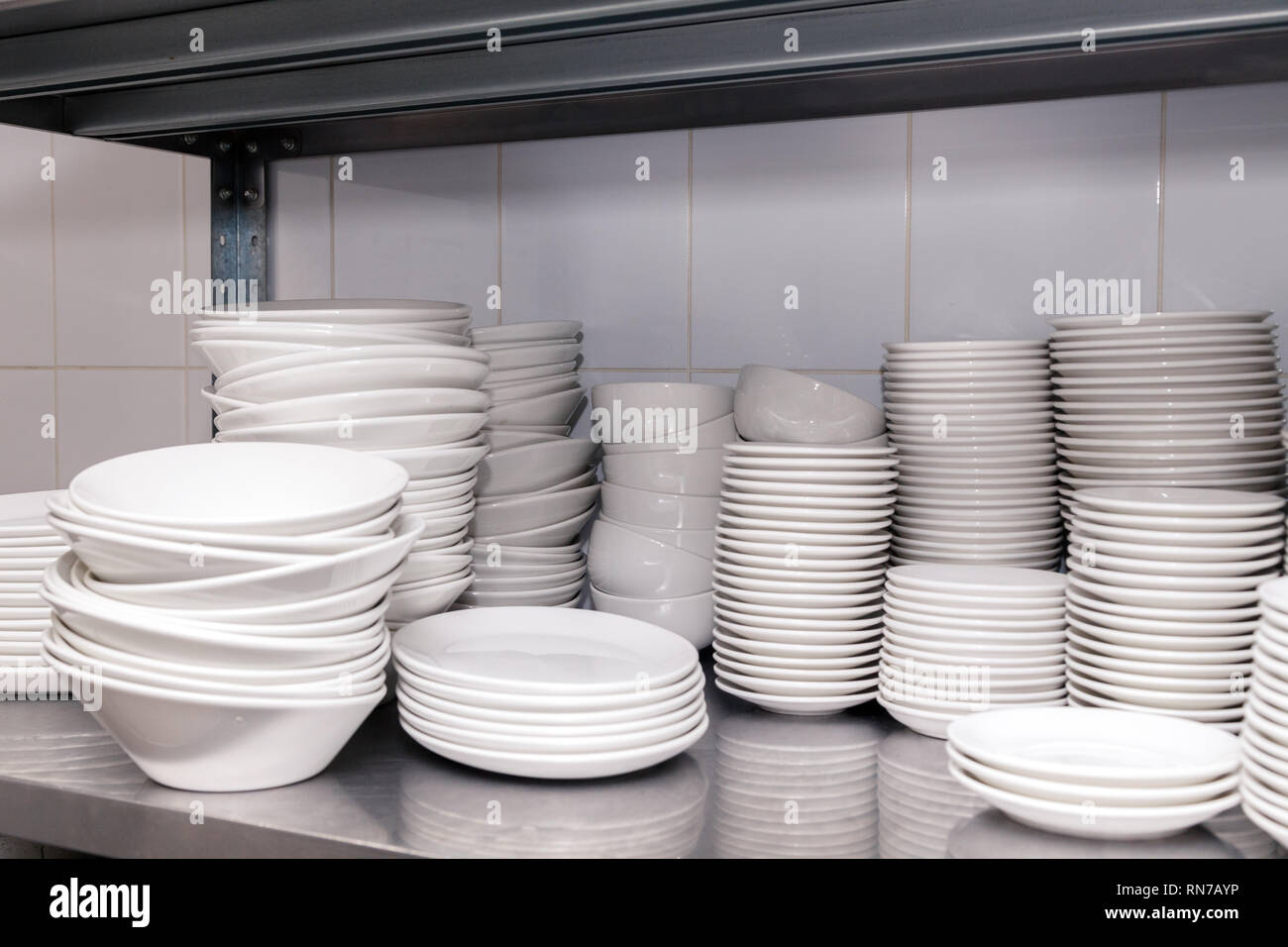 Pile d'assiettes en porcelaine blanche céramique propre sur un rack en  métal à l'arrière du restaurant. Concept de préparation pour un banquet,  restauration, buffet Photo Stock - Alamy