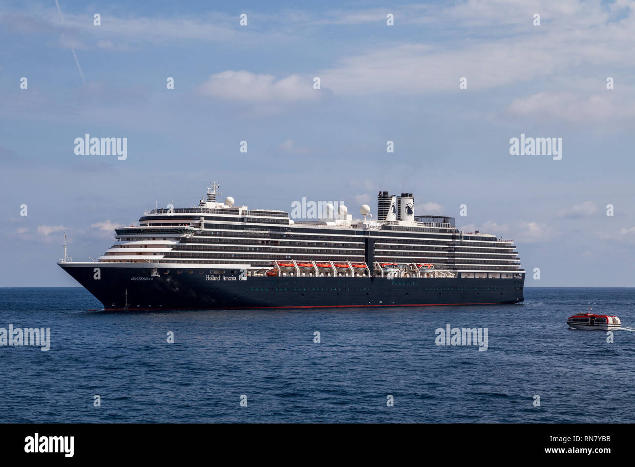 Une petite embarcation à moteur à l'équipage prend MS Oosterdam escales, un navire de croisière de la Holland America Line ancré près de Port Hercule sur une journée ensoleillée. Monaco Banque D'Images