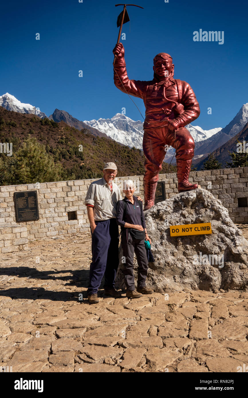 Le Népal, Namche Bazar, le parc national de Sagarmatha, Centre des visiteurs, promeneurs senior à Sherpa Tenzing Norgay memorial statue avec le Mont Everest derrière Banque D'Images