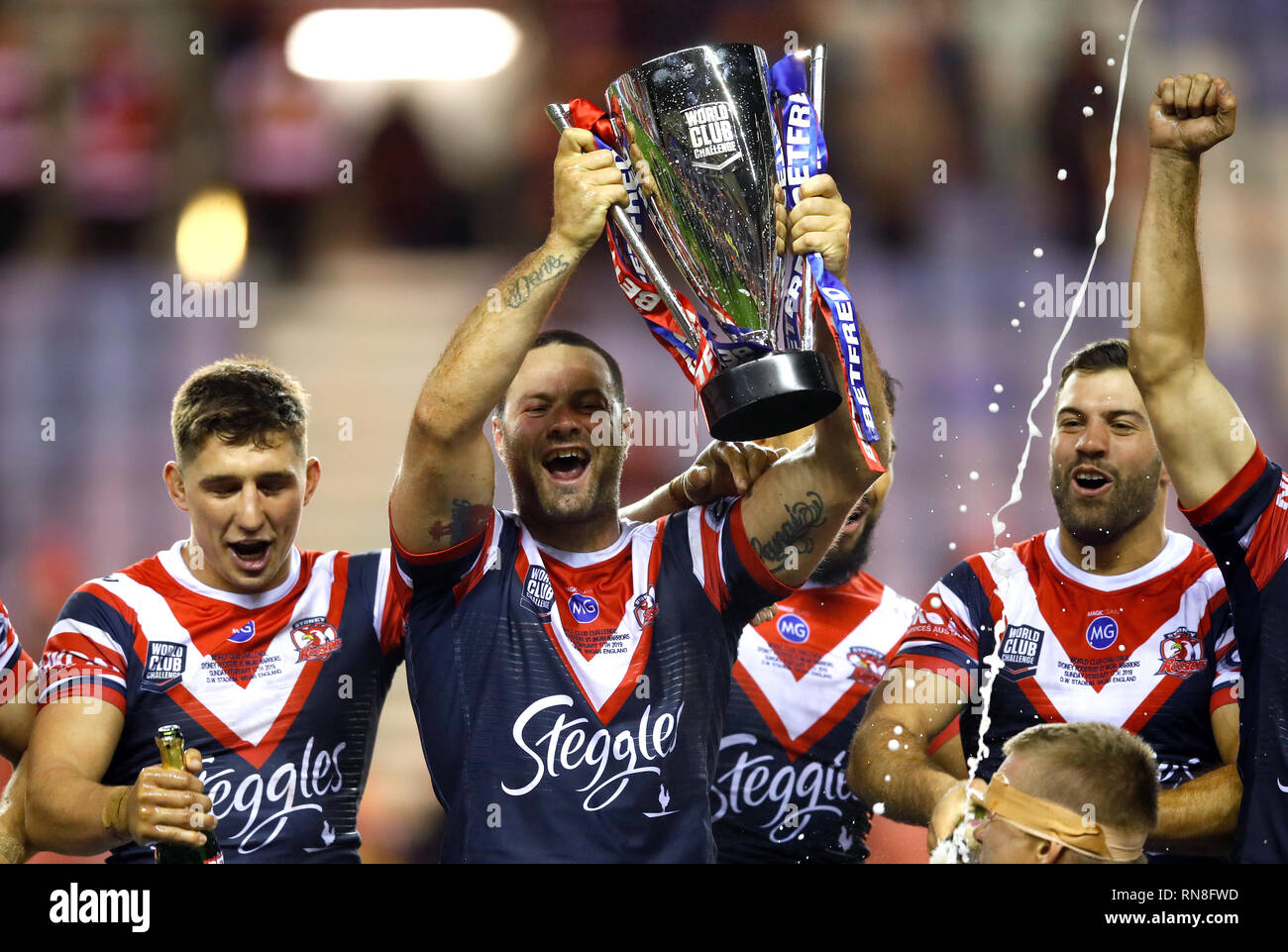 Sydney Roosters' Boyd Cordner (deuxième à gauche) et ses coéquipiers célèbrent avec le trophée après avoir remporté le World Club Challenge match à la DW Stadium, Wigan. Banque D'Images