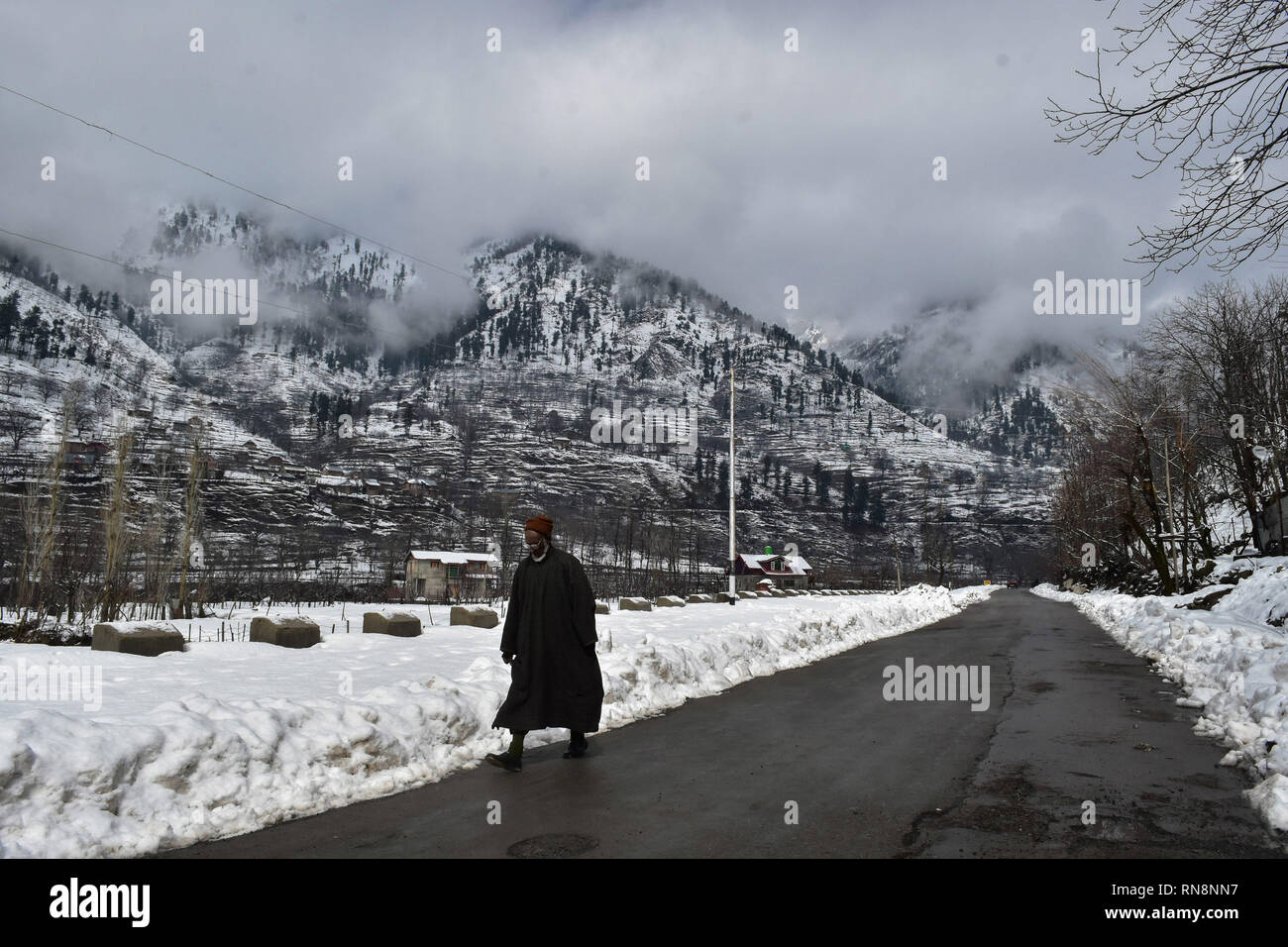 Un homme vu marchant à travers une route au cours d'une journée d'hiver nuageux à Pahalgam, à environ 110 kms de Srinagar, Cachemire sous administration indienne. La vallée du Cachemire demeure principalement nuageux le dimanche, avec la pluie et des orages dispersés à travers l'état pour les deux à trois jours, une prévision météorologique locale Ministère dit. Banque D'Images