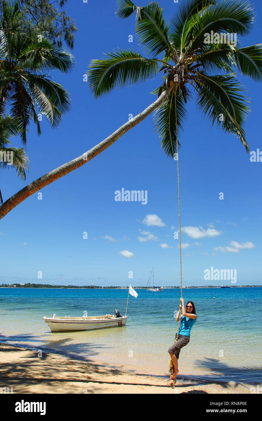 Jeune femme se balançant sur une corde swing sur l'île près de l'île de Tongatapu Pangaimotu à Tonga. Royaume de Tonga est un archipel composé de 169 îles Banque D'Images