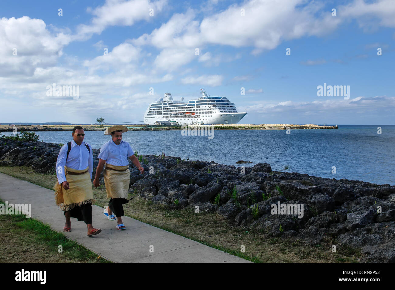 Les hommes de marcher au bord de l'eau dans Nuku'alofa, Tonga sur l'île de Tongatapu. Nukuʻalofa est la capitale du Royaume des Tonga Banque D'Images