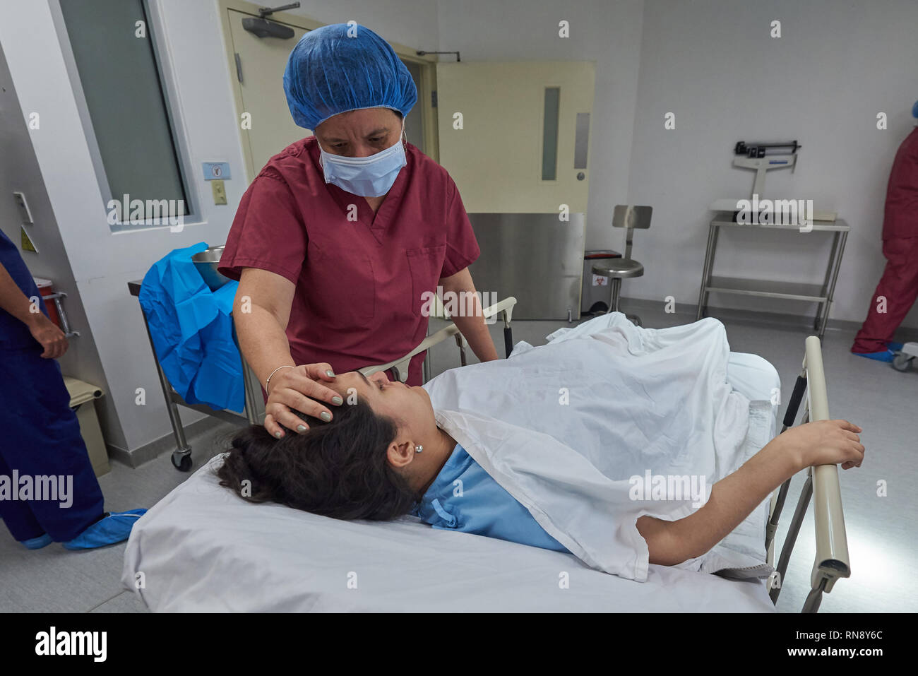 Préparation avant la chirurgie thème. Femme infirmière aidant à patient Banque D'Images