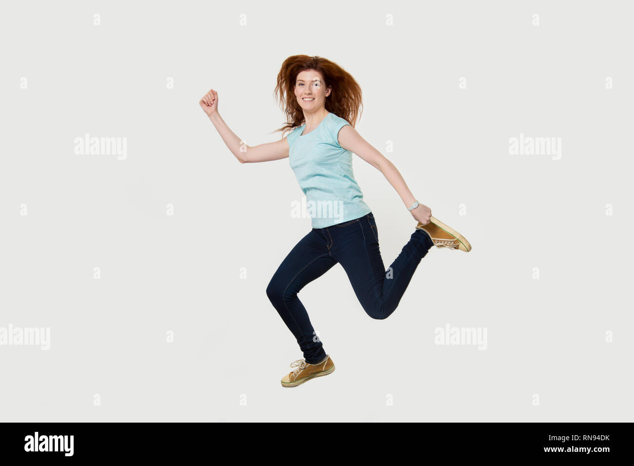 Happy active fit woman running se dépêcher de sauter dans l'air Banque D'Images