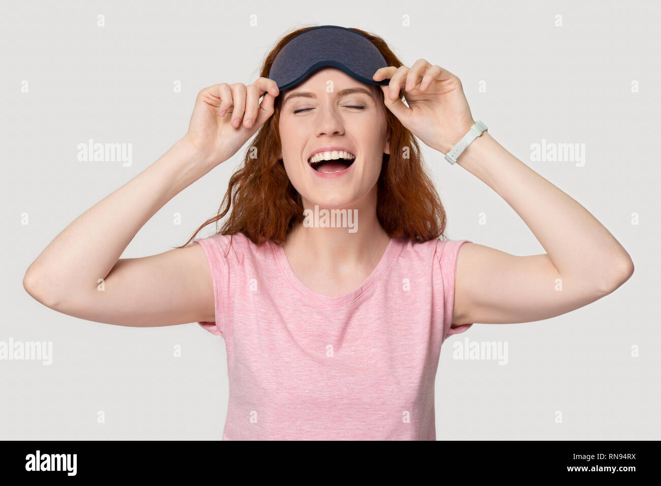 Happy funny red-haired woman laughing portant ce masque de sommeil Banque D'Images